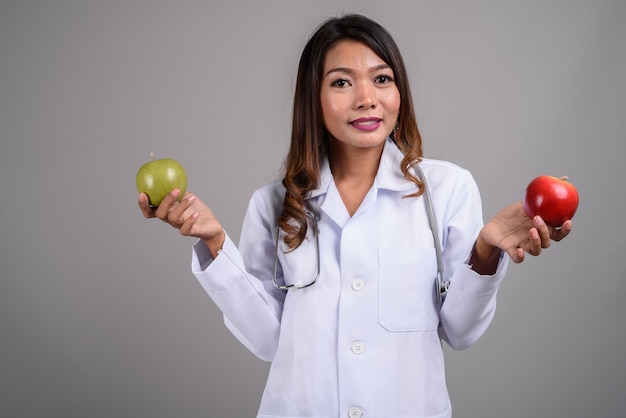 Portrait of Asian woman doctor holding two apples