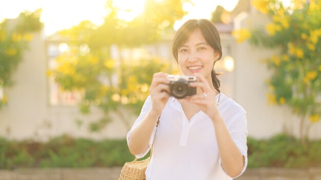 Portrait of asian woman traveler using camera at street of Bangkok Thailand Asia summer tourism vacation concept