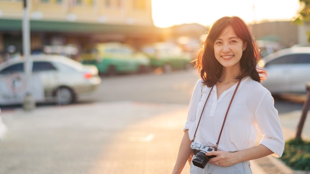 Portrait of asian woman traveler using camera at street of Bangkok Thailand Asia summer tourism vacation concept