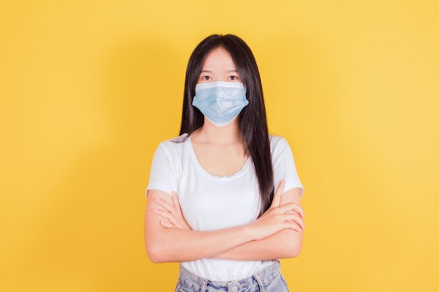 Portrait of Asian women in medical face mask to protect Covid19 Coronavirus on yellow background health and medicine concept