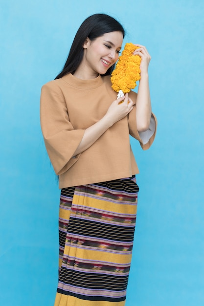 Portrait of asian young girl in traditional thai dress and holding  marigold garland