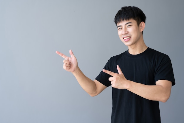 Portrait of Asian young handsome man smiling on gray