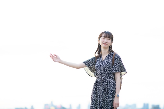 Portrait of asian young woman standing by the sea in evening