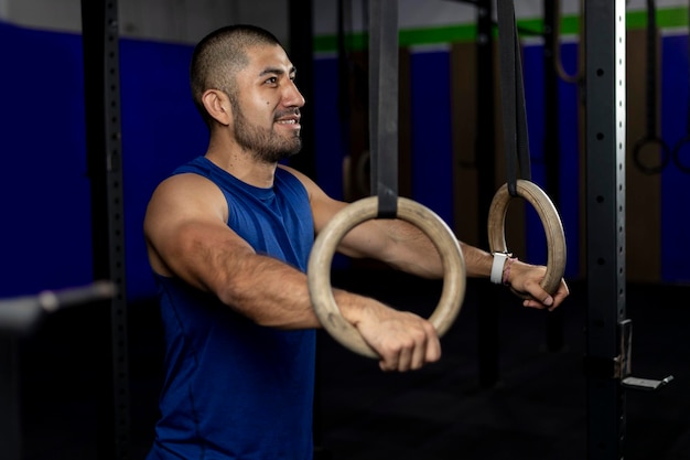 Portrait of an athlete standing leaning on gymnastic rings at a training site