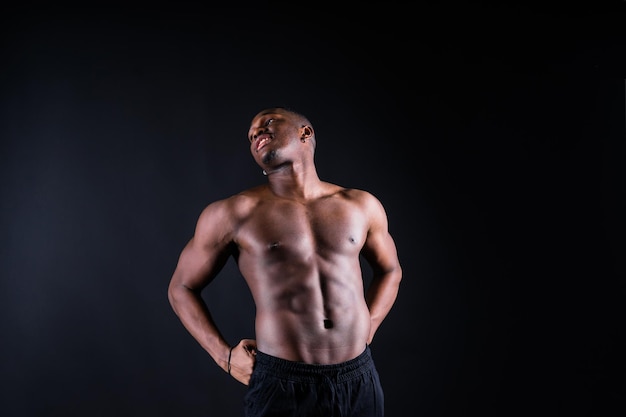 Portrait of an athletic african american man topless black background