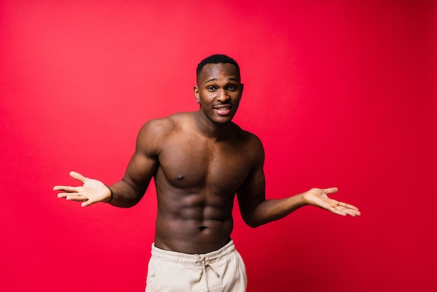 Portrait of an athletic african american man topless smiling yellow red and black background