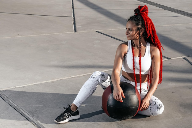 Portrait Athletic woman doing exercise with med ball Strength and motivationPhoto of sporty woman in fashionable sportswear