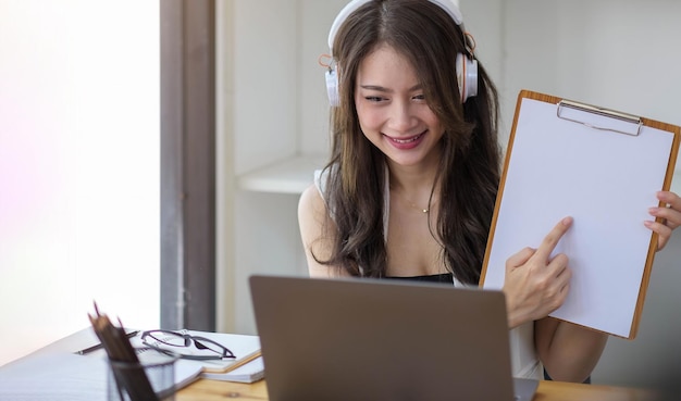 Portrait of attractive asian woman looking at camera smiling with confident working with smart tablet and positive lifestyle concept at cafe