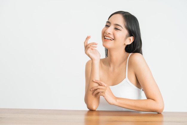 Portrait of attractive asian woman skin care image on white wall