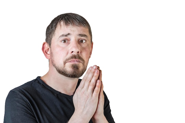 Portrait of an attractive bearded man of European appearance with a slight gray hair on an isolated white background He folded his hands to pray Expression of emotions of a man