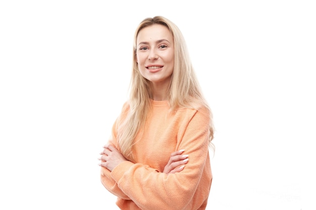 Portrait of attractive blonde girl in orange casual posing and smiling joyfully isolated on white studio background