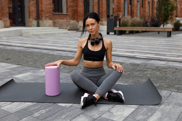 Portrait of attractive caucasian brunette woman with muscular during exercising on city street