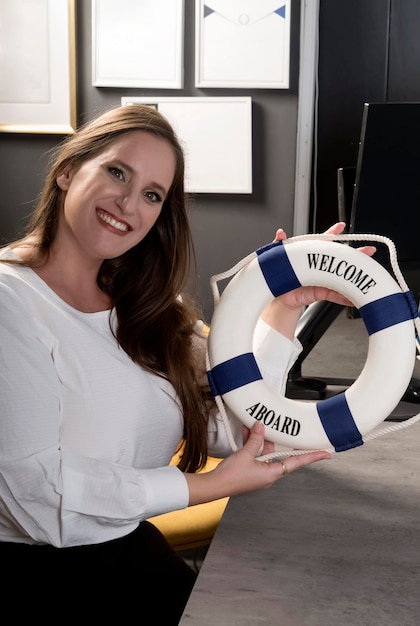 Portrait of attractive caucasian smiling woman and hugging lifebuoy Women's hands with small lifebuoy Businesswoman workers sitting at desk Woman with long hair and perfect smile and white teeth