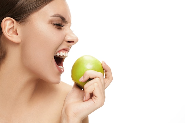 The portrait of attractive caucasian smiling woman isolated on white studio background with green apple fruits. The beauty, care, skin, treatment, health, spa, cosmetic and advertising concept