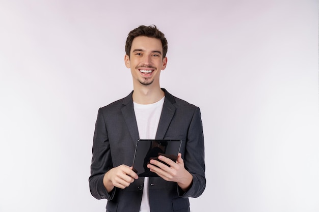 Portrait of attractive cheerful businessman using device app searching web isolated over white color background