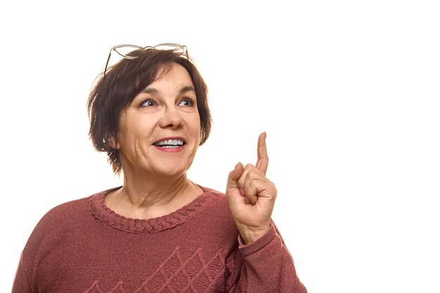 Portrait of attractive cheerful intelligent mature woman pointing forefinger up isolated over white