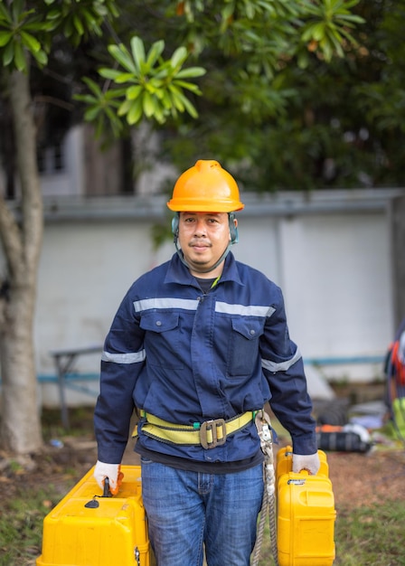 Portrait of an attractive electrician in uniform on a construction site with a power wire for the network Electrical Engineer at a Power Station