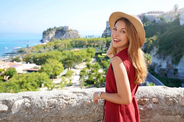 Portrait of attractive fashion model turns around to the camera in Tropea village Calabria Italy