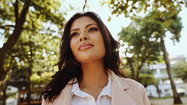 Portrait of an attractive Latin woman walking in the park at fall on a sunny day and smiling The face of a happy beautiful woman outdoor