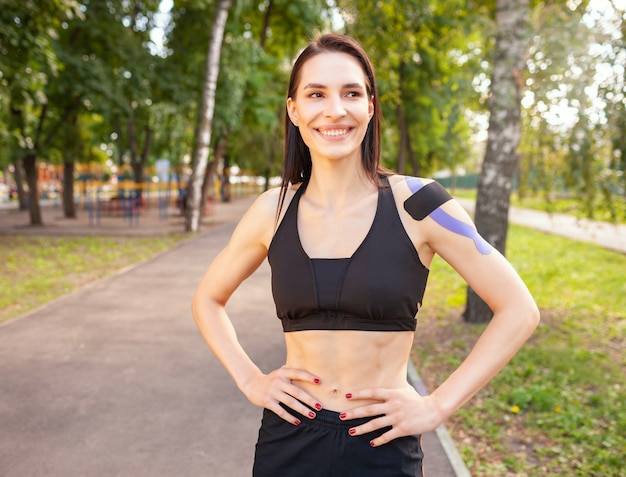 Portrait of attractive muscular brunette woman wearing black sports outfit