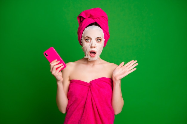 Portrait of attractive nude amazed lady wearing turban facial mask using gadget news reaction isolated over bright green color background