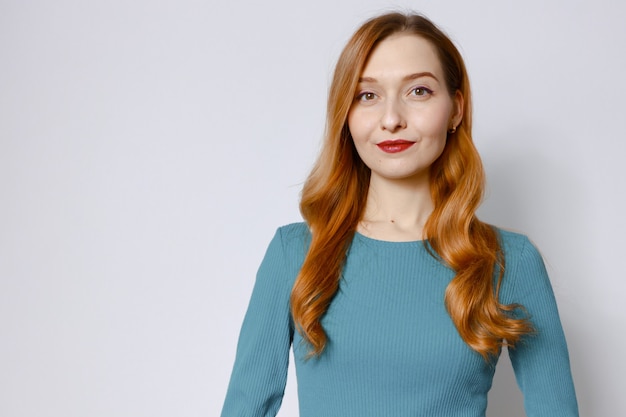 Portrait of an attractive red-haired woman in a blue dress