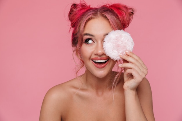 Portrait of attractive shirtless woman with colorful hairstyle holding powder puff