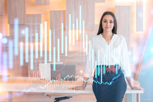 Portrait of attractive smiling businesswoman in formal wear thinking how to optimize trading strategy at corporate finance fund Forex chart hologram over modern office background