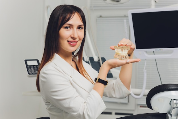 Portrait of attractive smiling female dentist with hands folded