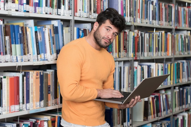 Portrait of an Attractive Student Doing Some School Work With a Laptop in the Library