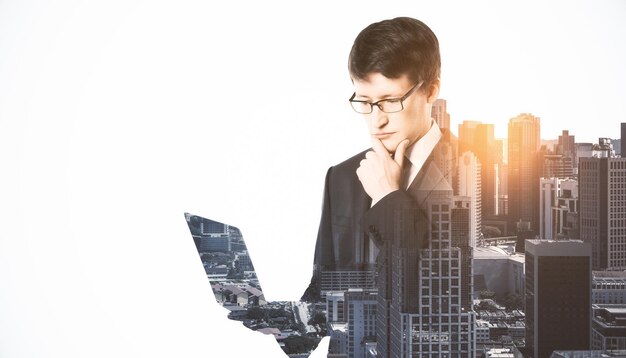 Portrait of attractive thoughtful european businessman using laptop on bright city background with mock up place Technology communication and success concept Double exposure