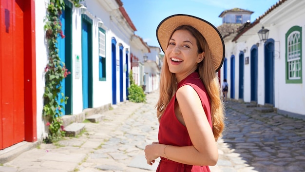 Portrait of attractive tourist woman in Paraty Rio de Janeiro Brazil UNESCO World Heritage Site Looking at camera Panoramic banner