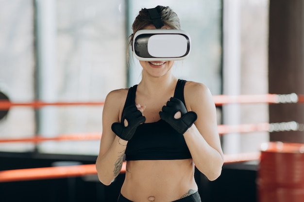 Portrait Attractive woman boxing in VR 360 headset training for kicking in virtual reality