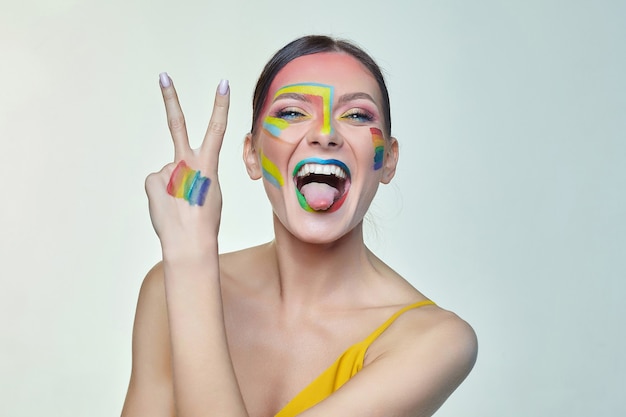 Portrait of an attractive woman with bright makeup with rainbow LGTB flag