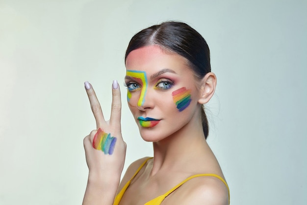 Portrait of an attractive woman with bright makeup with rainbow LGTB flag