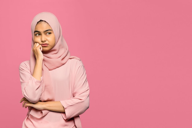 Portrait of attractive young Asian woman thinking and looking up