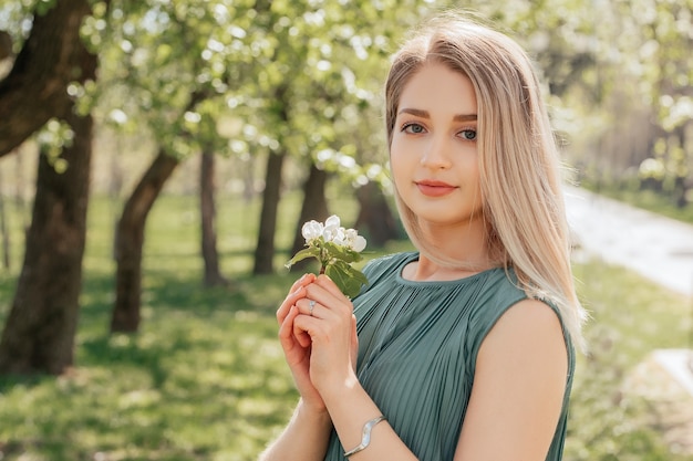 Portrait of attractive young blonde woman in spring garden