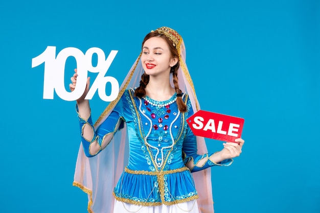 portrait of azeri woman in traditional dress holding sale text and percent discount