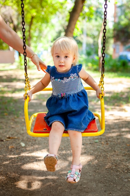 Portrait of baby 1-2 years old. Happy caucasian child girl playing toys at the playground. Girl smiling. Kids and sport concept.