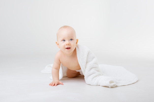 Portrait of a baby   on a white background with a bath towel