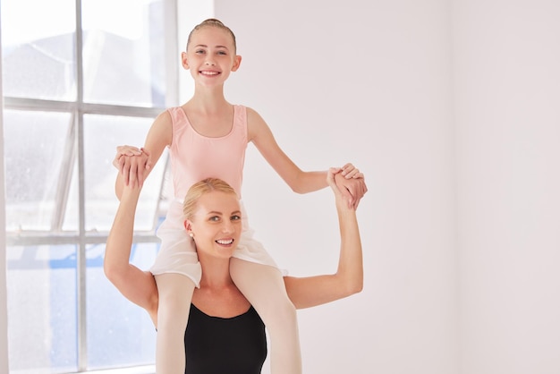 Portrait of ballet teacher carrying girl student with smile in a dance classroom or studio Woman and young ballerina having fun after learning training and practice dancing in a theater together