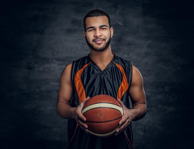 Portrait of a bearded black man holds a basket ball.