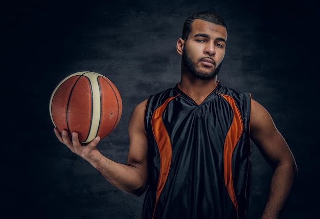 Portrait of a bearded black man holds a basket ball.