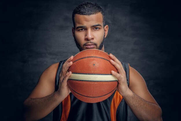 Portrait of a bearded black man holds a basket ball.