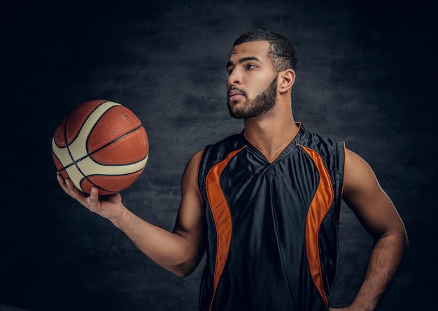 Portrait of a bearded black man holds a basket ball.