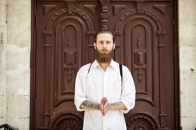 Portrait of bearded hipster in front of a door. Style and diversity