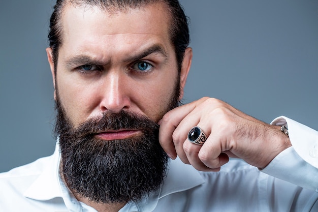 Portrait of bearded male in white shirt. Close up of handsome beard hipster elegant male. Bearded man close up. Beard is his style. Male with mustache growing.