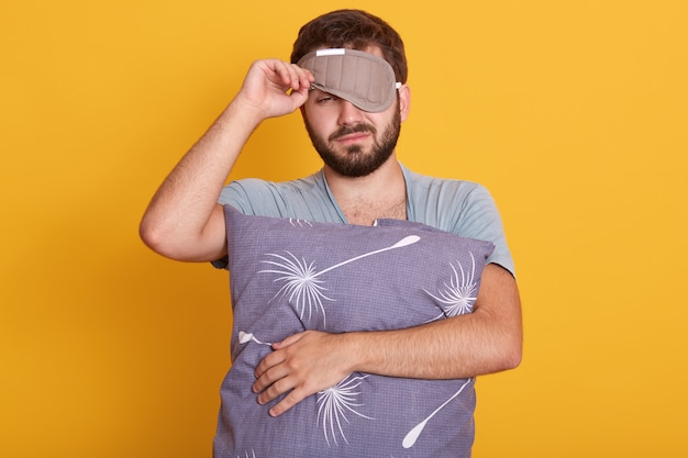 Portrait of bearded man in dressing gown and mask to sleep on his head