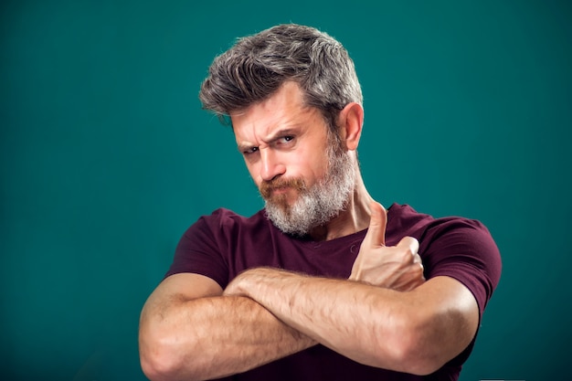 A portrait of bearded man in red t-shirt showing thumb up gesture. People and emotions concept