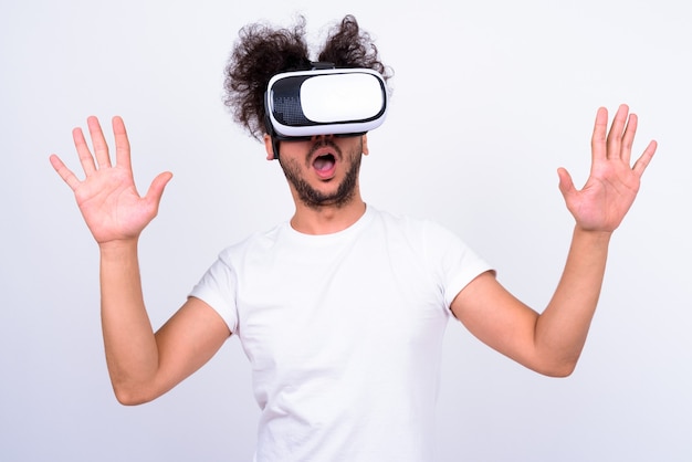 Portrait of bearded Turkish man with curly hair using virtual reality headset